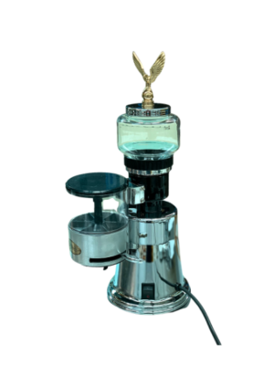 Elektra MSC Coffee Grinder in chrome front right hand view. Image shows the contrasting brass eagle positioned onto the chrome bean hopper lid. It's not only decorative but works as the hopper lid handle. The coffee bean hopper is made of glass. There's a coffee grinds chamber with a chrome dispensing lever used to dispense the ground coffee into the portafilter. The on/off switch is situated at the front right hand side.