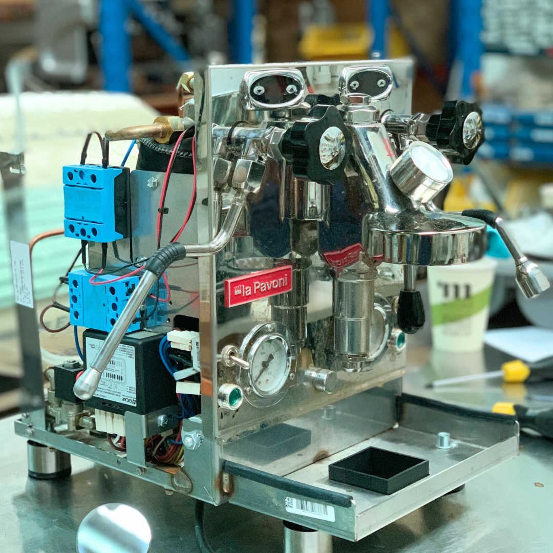 La Pavoni Botticelli Evolution under warranty repair rear view with side panels removed. You have acomplete visual of the internal components such as the two solid stat relays that control the steam and coffee boilers and the water level contol module along with the insulated boilers.